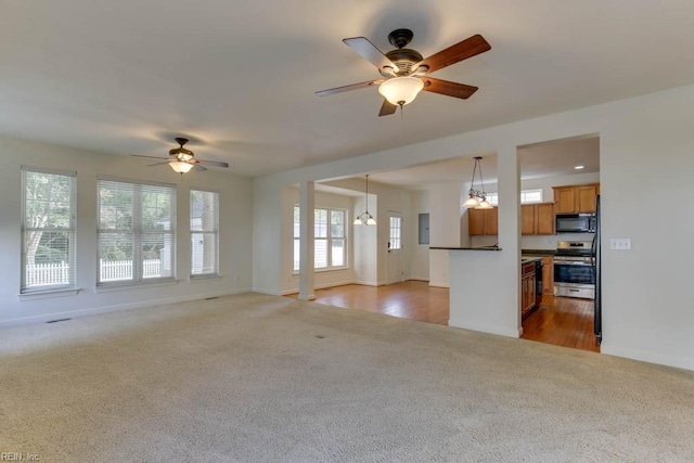 unfurnished living room featuring dark carpet and ceiling fan