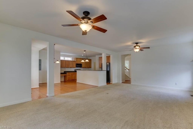 unfurnished living room featuring light carpet and ceiling fan