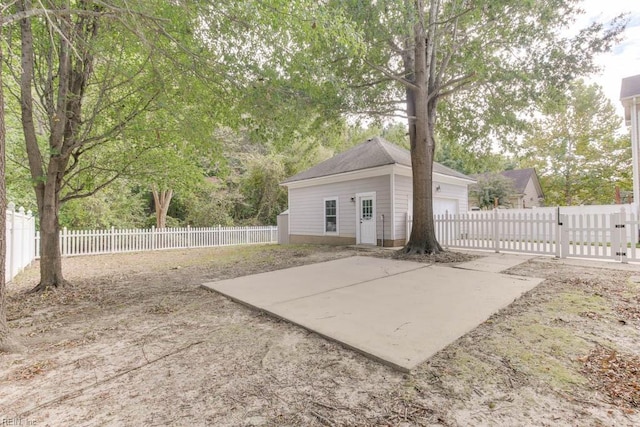 view of patio with a garage and an outbuilding