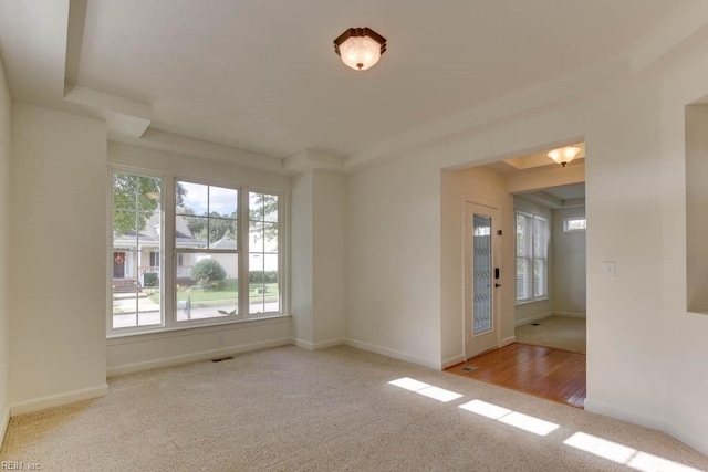 unfurnished room featuring light carpet