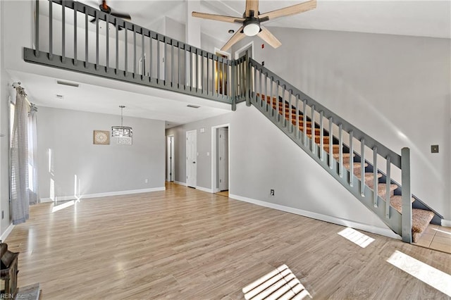 unfurnished living room featuring high vaulted ceiling, light hardwood / wood-style floors, and ceiling fan