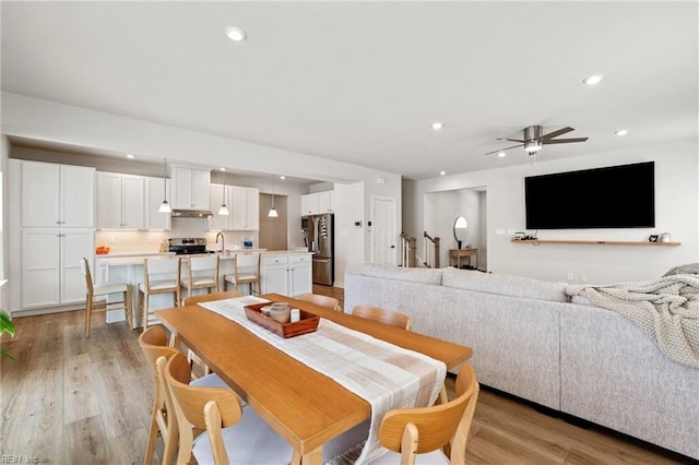 dining room with ceiling fan and light wood-type flooring