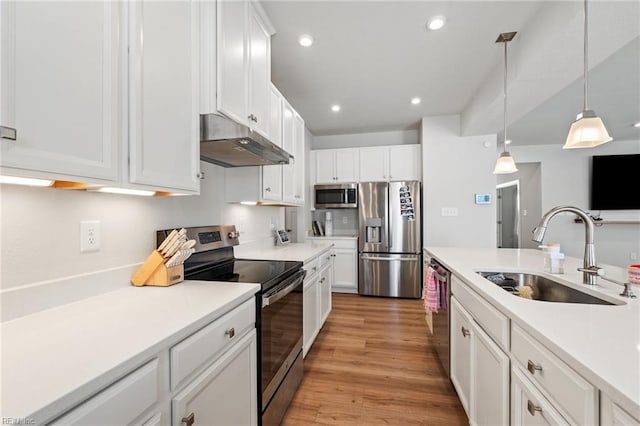 kitchen featuring pendant lighting, sink, light hardwood / wood-style flooring, stainless steel appliances, and white cabinets