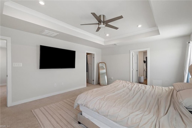 bedroom with light colored carpet, ceiling fan, and a tray ceiling