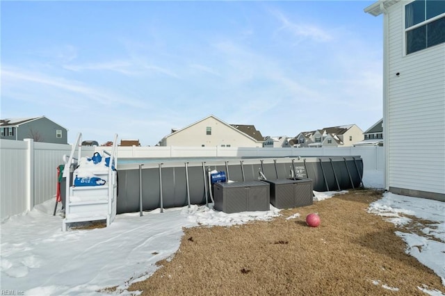 yard covered in snow with a fenced in pool