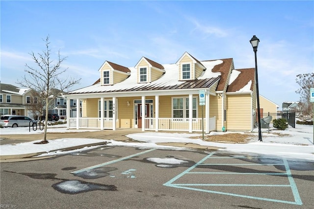 cape cod home featuring a porch