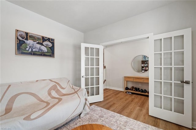 living area with hardwood / wood-style flooring and french doors