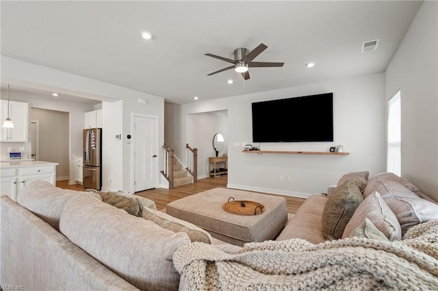 living room with ceiling fan and light hardwood / wood-style flooring