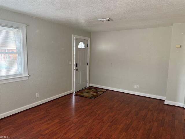 foyer with dark hardwood / wood-style floors and a textured ceiling