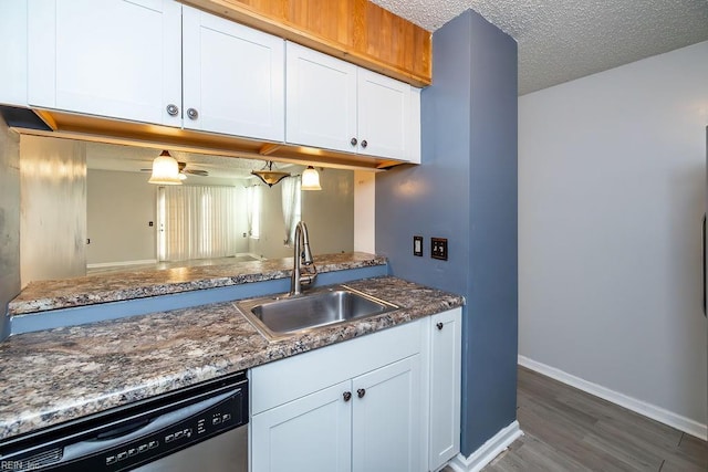 kitchen featuring sink, white cabinetry, a textured ceiling, stainless steel dishwasher, and hardwood / wood-style flooring