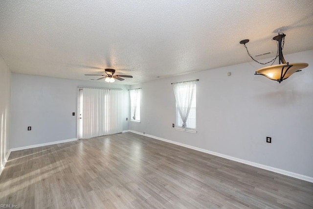 empty room featuring hardwood / wood-style floors, a textured ceiling, and ceiling fan