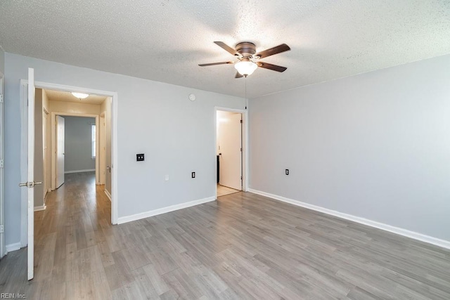 spare room with ceiling fan, a textured ceiling, and light hardwood / wood-style flooring