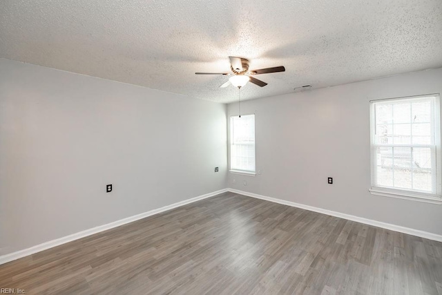 empty room with ceiling fan, hardwood / wood-style floors, and a textured ceiling