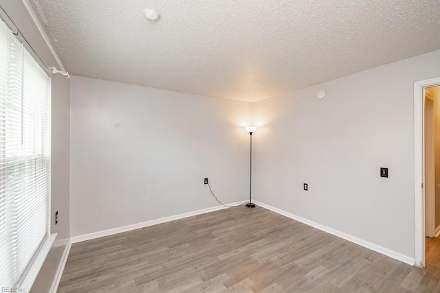 spare room with hardwood / wood-style floors and a textured ceiling