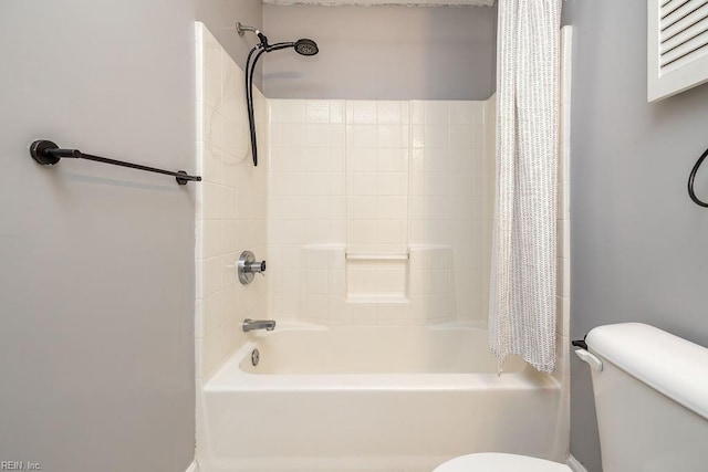 bathroom featuring shower / bath combination with curtain and toilet