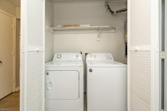 washroom featuring hardwood / wood-style floors and washing machine and dryer