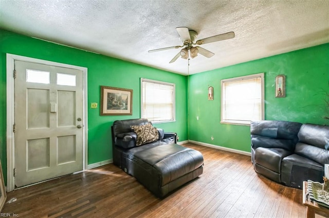 sitting room with hardwood / wood-style flooring, ceiling fan, and a textured ceiling