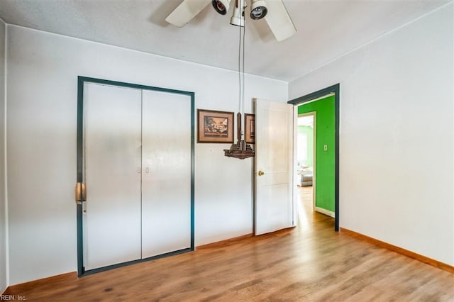 unfurnished bedroom with hardwood / wood-style flooring, ceiling fan, and a closet