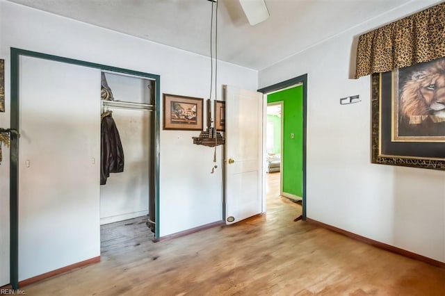 unfurnished bedroom with hardwood / wood-style flooring, ceiling fan, and a closet