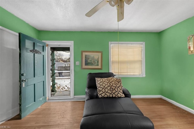 sitting room with hardwood / wood-style floors, a textured ceiling, and ceiling fan