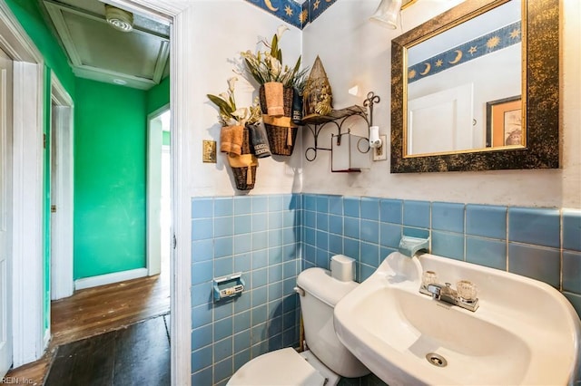 bathroom with tile walls, sink, and toilet