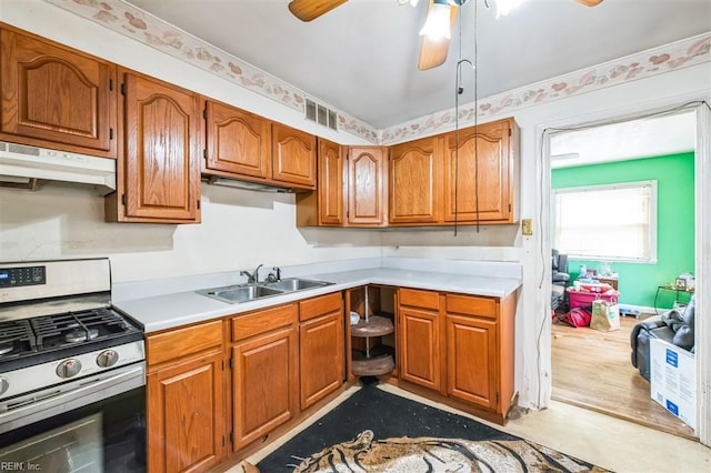 kitchen with gas stove, sink, and ceiling fan