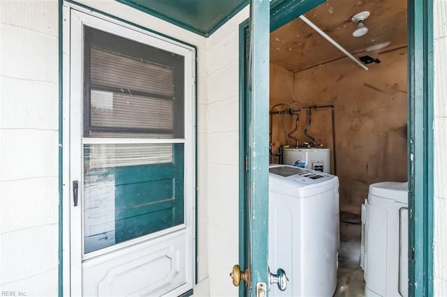 washroom with electric water heater and washer and clothes dryer