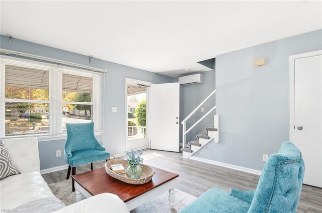 living room with light wood-type flooring, a wall unit AC, and a wealth of natural light