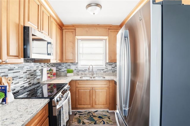 kitchen featuring sink, decorative backsplash, light stone countertops, and appliances with stainless steel finishes