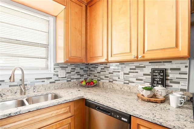 kitchen with sink, dishwasher, tasteful backsplash, light stone counters, and a healthy amount of sunlight