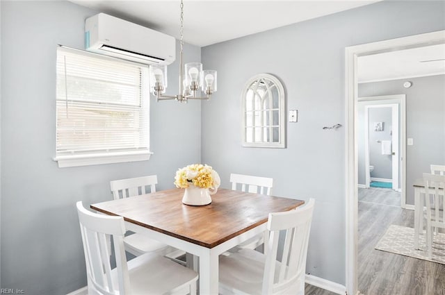 dining area with a wall mounted air conditioner, a notable chandelier, and hardwood / wood-style floors