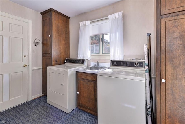 washroom with cabinet space, a sink, and washing machine and clothes dryer