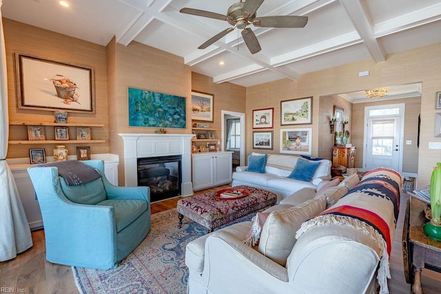 living room featuring coffered ceiling, light hardwood / wood-style flooring, built in features, ceiling fan, and beam ceiling