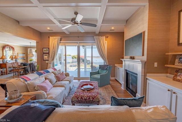 living room featuring coffered ceiling, ceiling fan, wood-type flooring, and beamed ceiling