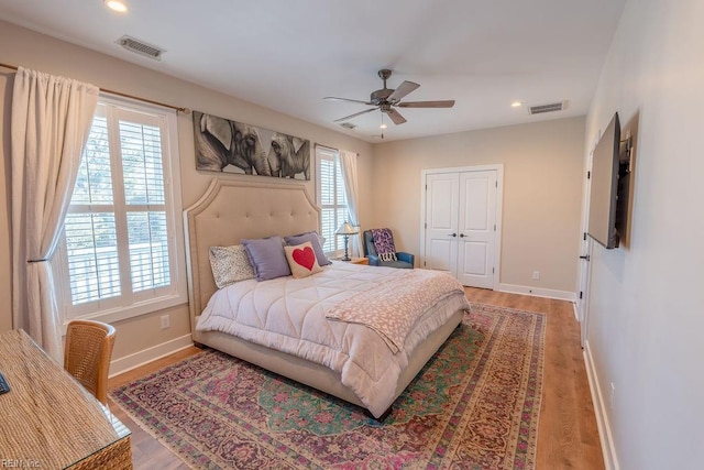 bedroom with hardwood / wood-style flooring, ceiling fan, and a closet