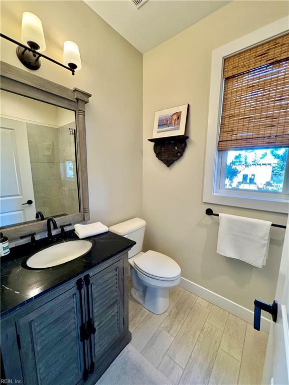 bathroom featuring vanity, plenty of natural light, and toilet