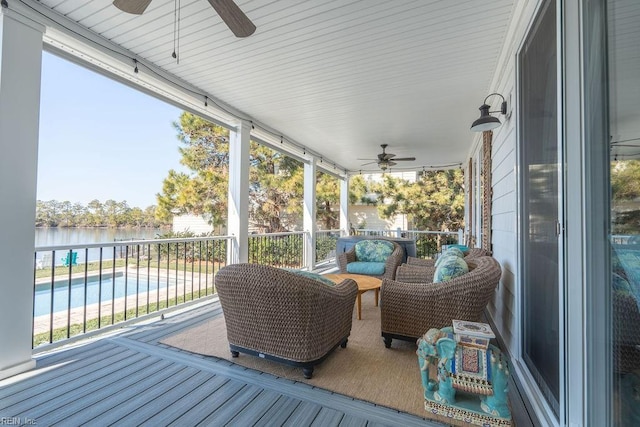 sunroom / solarium with a water view, a healthy amount of sunlight, and ceiling fan