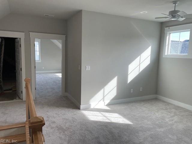 carpeted empty room with vaulted ceiling and ceiling fan