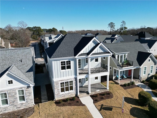 rear view of house featuring a balcony, a yard, and a patio