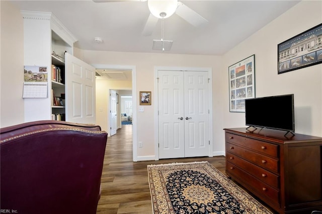 bedroom with dark wood-type flooring, ceiling fan, and a closet