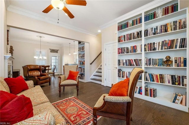 interior space with dark hardwood / wood-style flooring, crown molding, and ceiling fan with notable chandelier