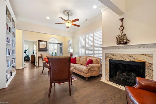 living room featuring ornamental molding, dark wood-type flooring, and a fireplace