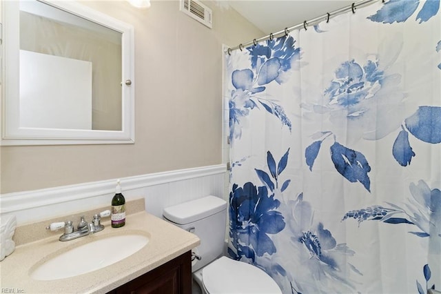 bathroom with vanity, a shower with shower curtain, and toilet