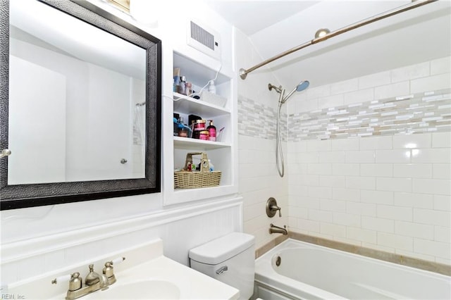 full bathroom featuring tiled shower / bath, vanity, and toilet