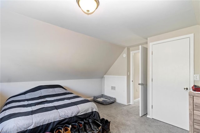 carpeted bedroom with lofted ceiling