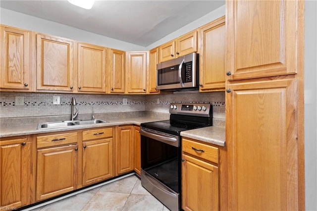 kitchen with vaulted ceiling, tasteful backsplash, sink, light tile patterned floors, and stainless steel appliances