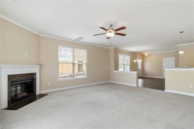 unfurnished living room featuring ornamental molding, carpet flooring, and ceiling fan with notable chandelier