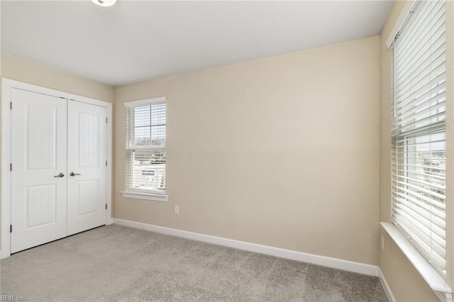 unfurnished bedroom with light carpet and a closet