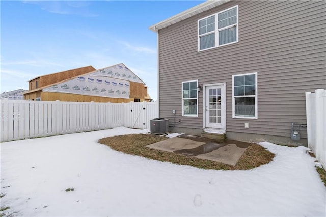 snow covered rear of property with central air condition unit