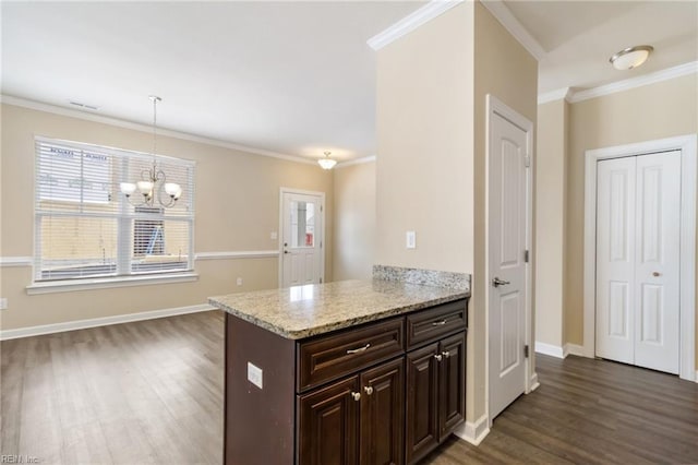 kitchen featuring crown molding, decorative light fixtures, dark brown cabinets, dark hardwood / wood-style floors, and light stone countertops